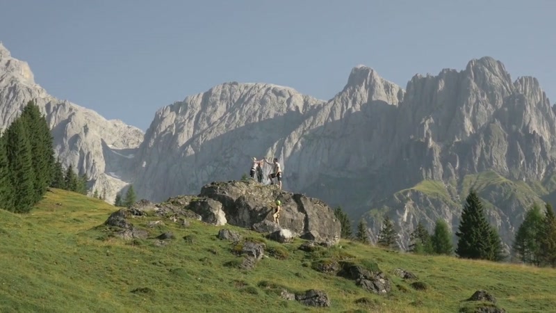 Familie jubelt auf einem Gipfelfelsen vor den Mandlwänden am Hochkönig