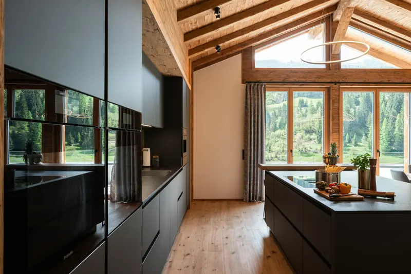 Miele-Küche mit Kochinsel, Holzbalken und Bergblick