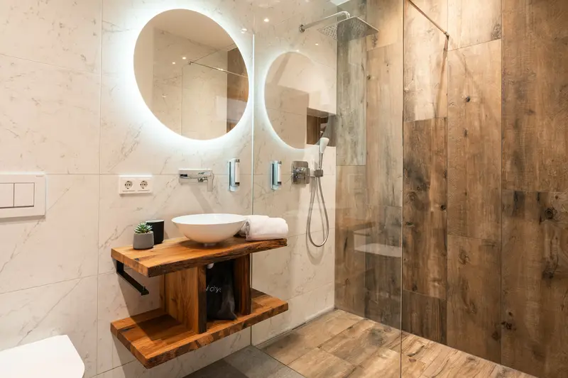 Design-Bad mit Holzwaschtisch und beleuchtetem Spiegel