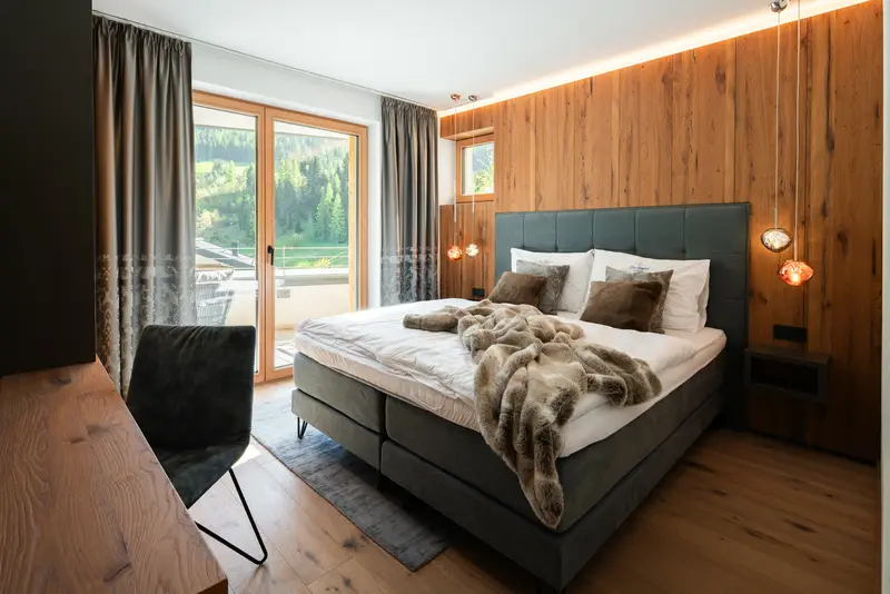 Suite mit Holzwand und Balkonblick auf die Berge