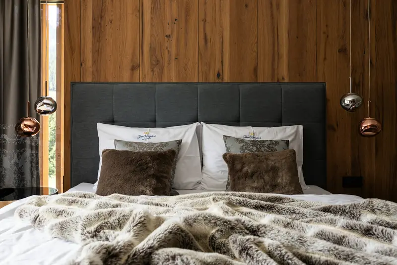 Ruhiges Schlafzimmer mit Holzwand und weicher Decke